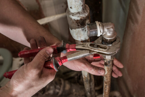 Plumber man replaces the tap in the bathroom. Fasten faucet using a wrench to rusty water pipePlumber man replaces the tap in the bathroom. Fasten faucet using a wrench to rusty water pipe