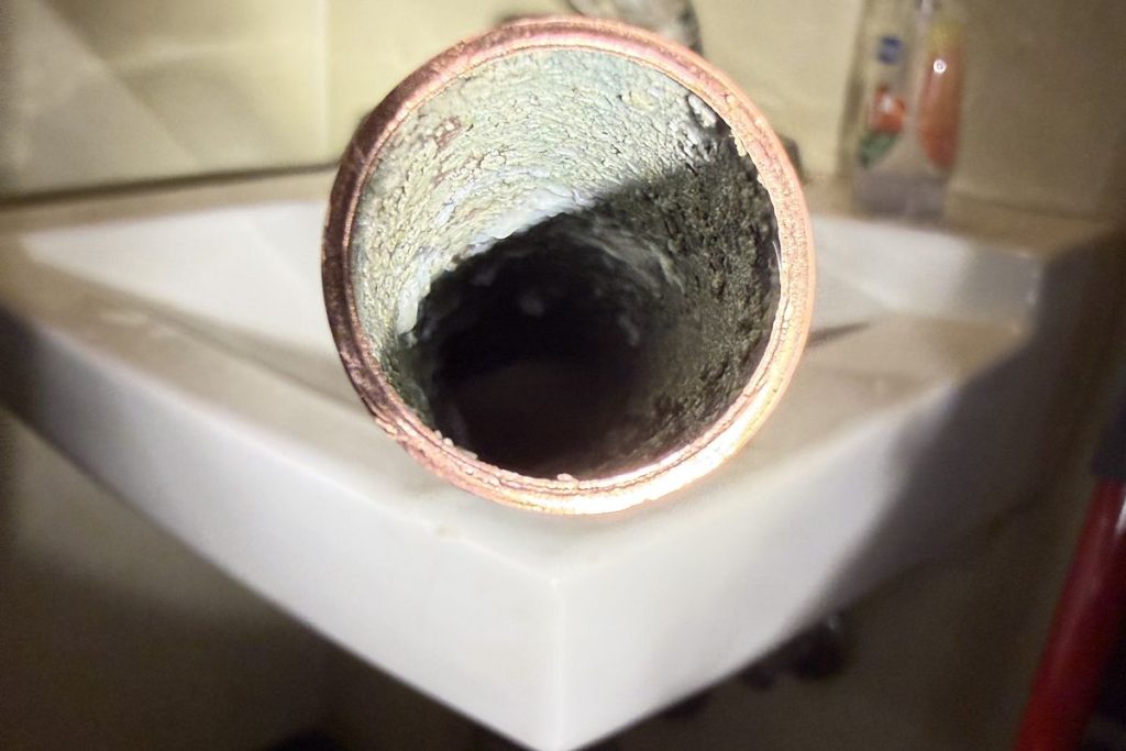Scaled cast iron pipe section cut out during a repair