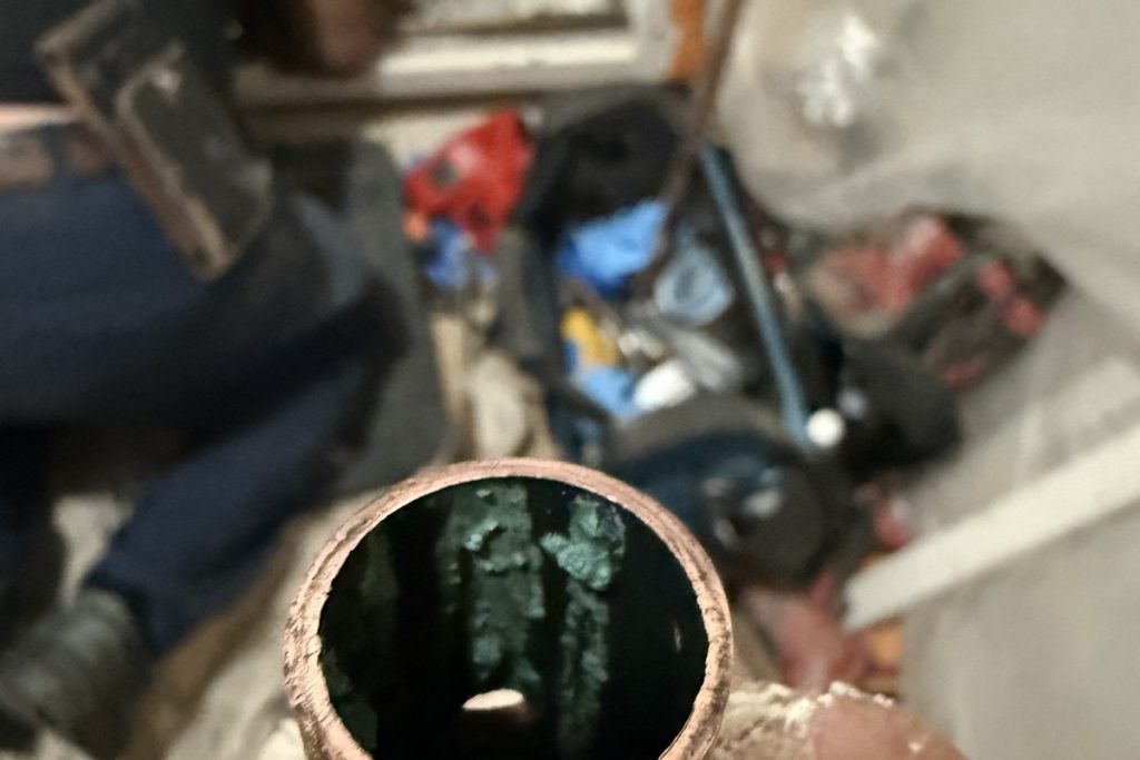 Cross-section of corroded copper pipe taken out of a wall