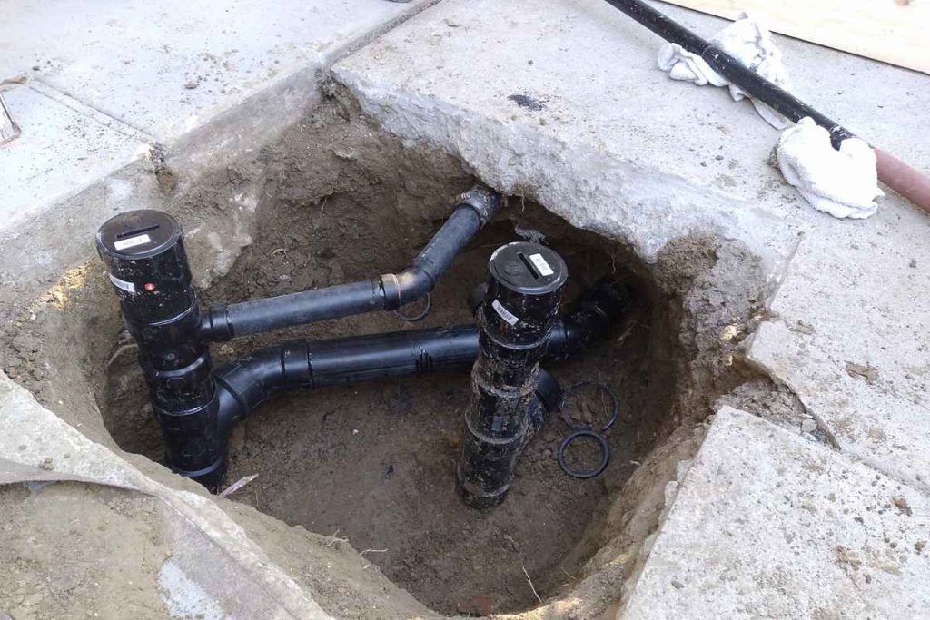 Sewer cleanouts and fittings set in a concrete pit