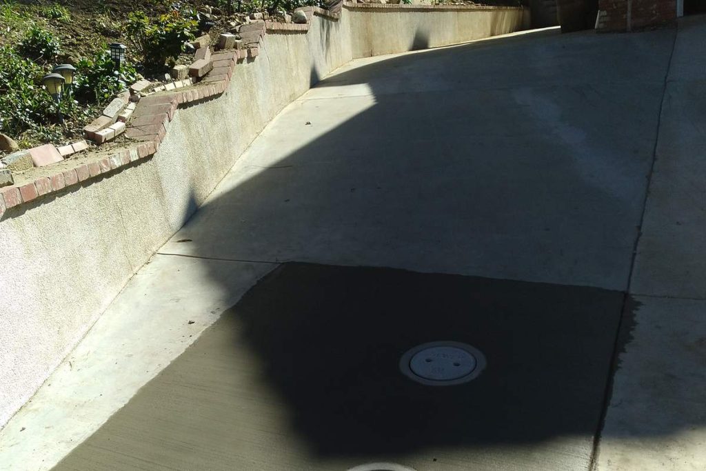 Finished concrete driveway patch over a sewer repair