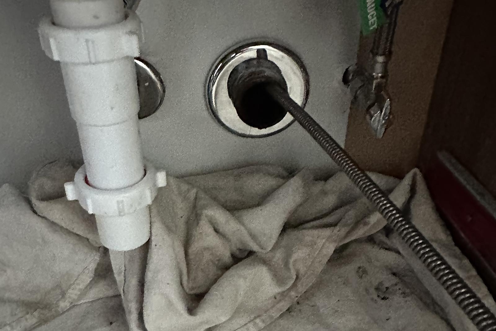 Drain cable fed into a floor cleanout on a drop cloth