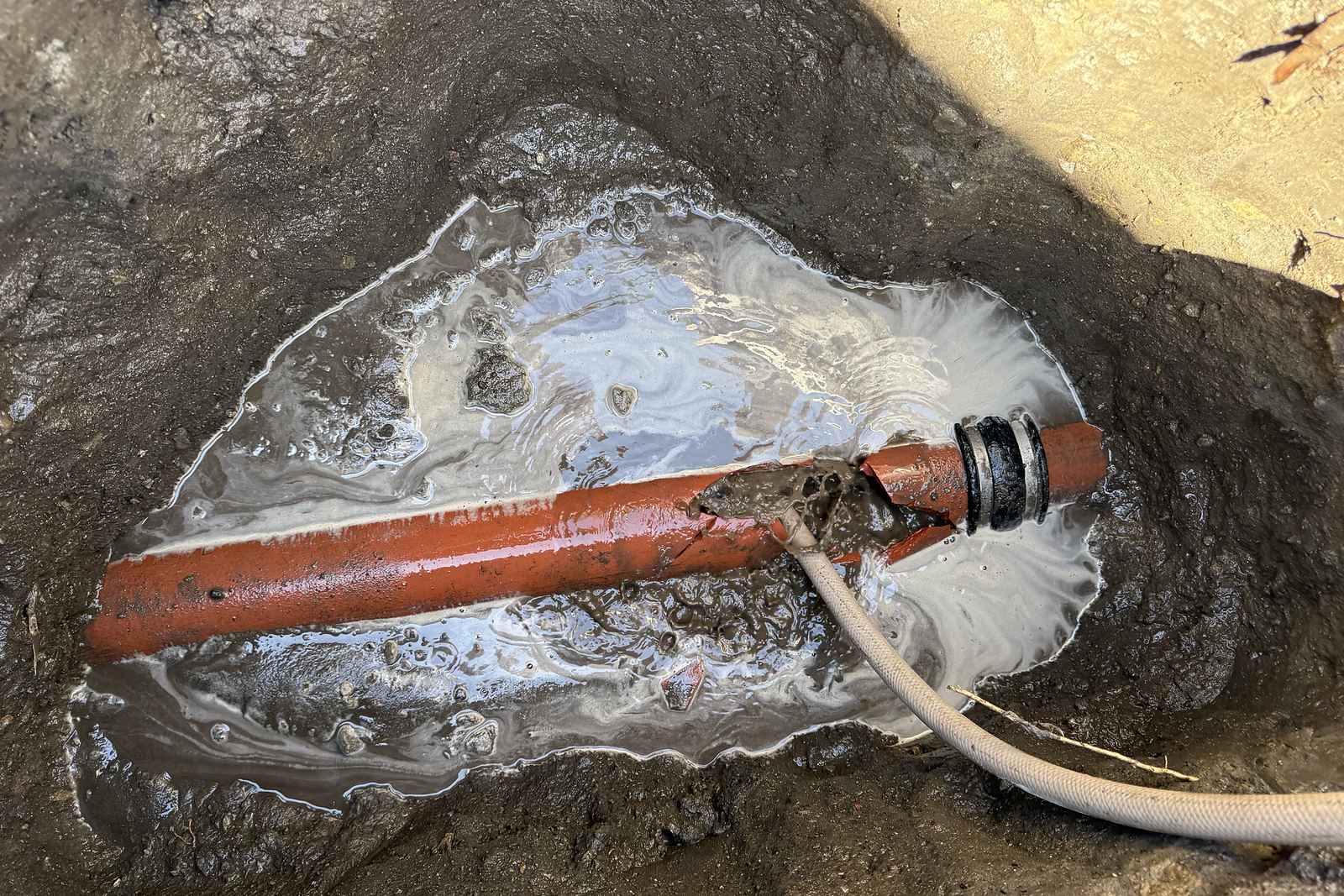 Jetting hose run into a sewer line to cut through the blockage