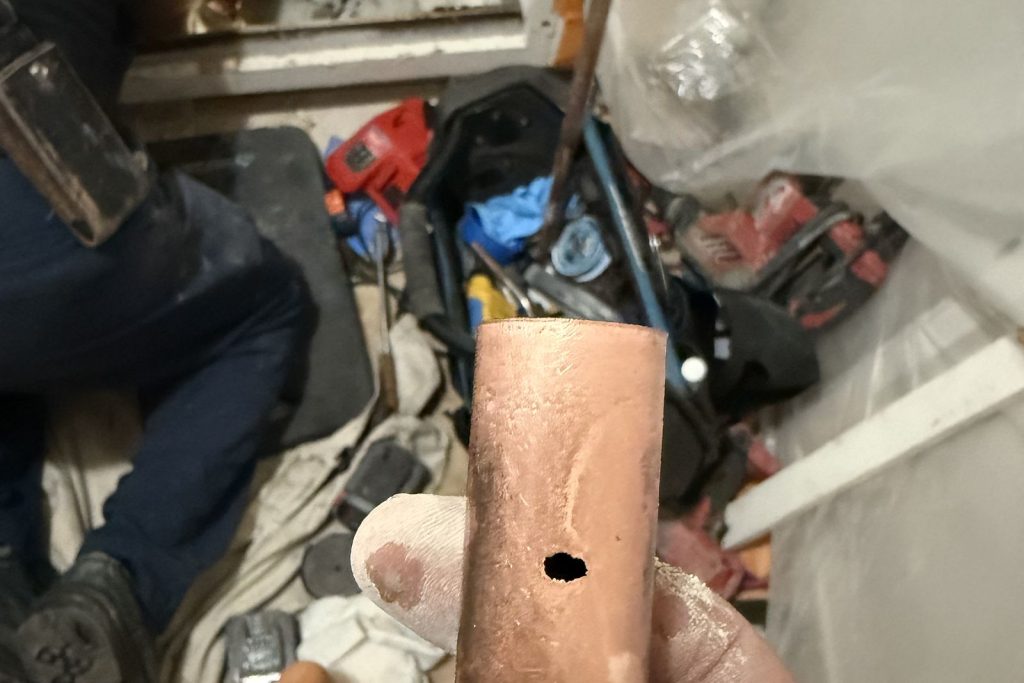 Pinhole leak found in a copper line beneath the floor