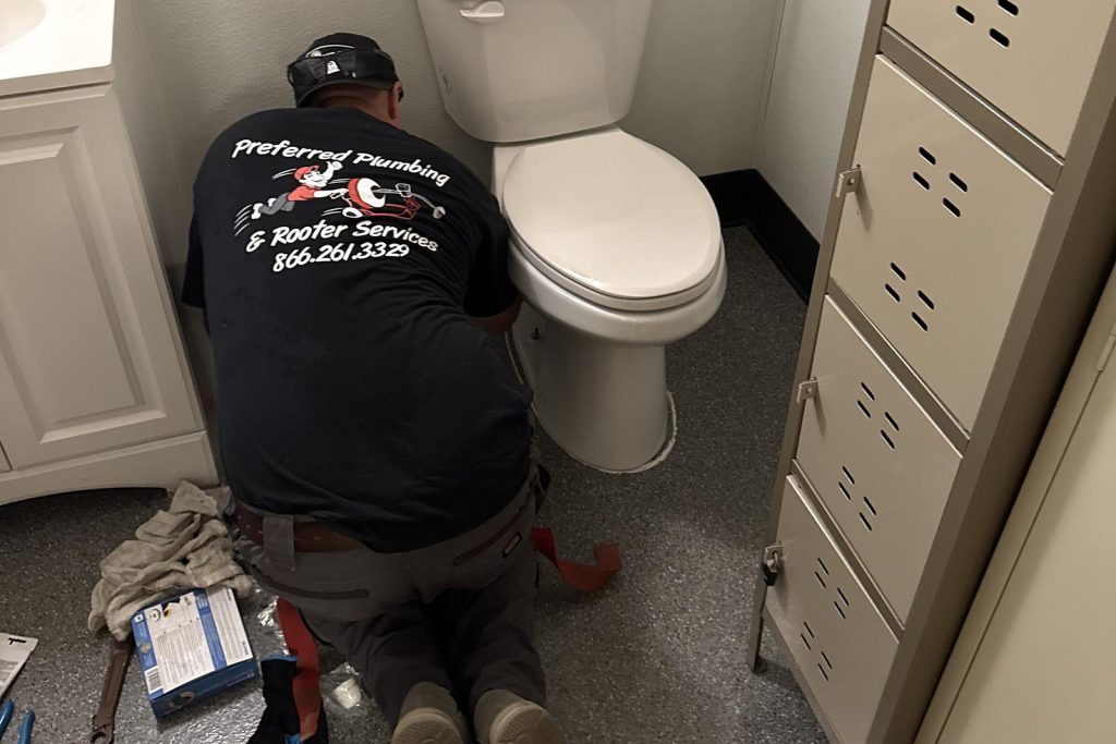 Preferred Plumbing technician servicing a commercial restroom toilet