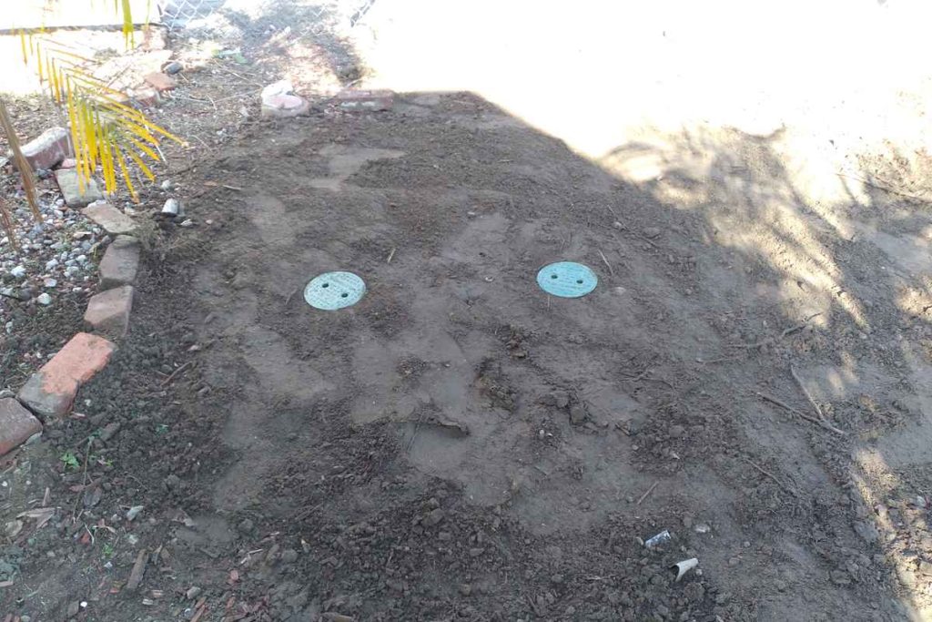 Backfilled yard with two new sewer cleanouts