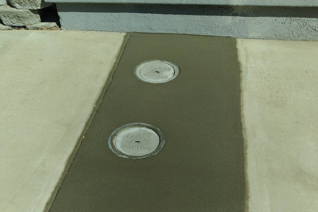 New concrete walkway with two sewer cleanouts set flush