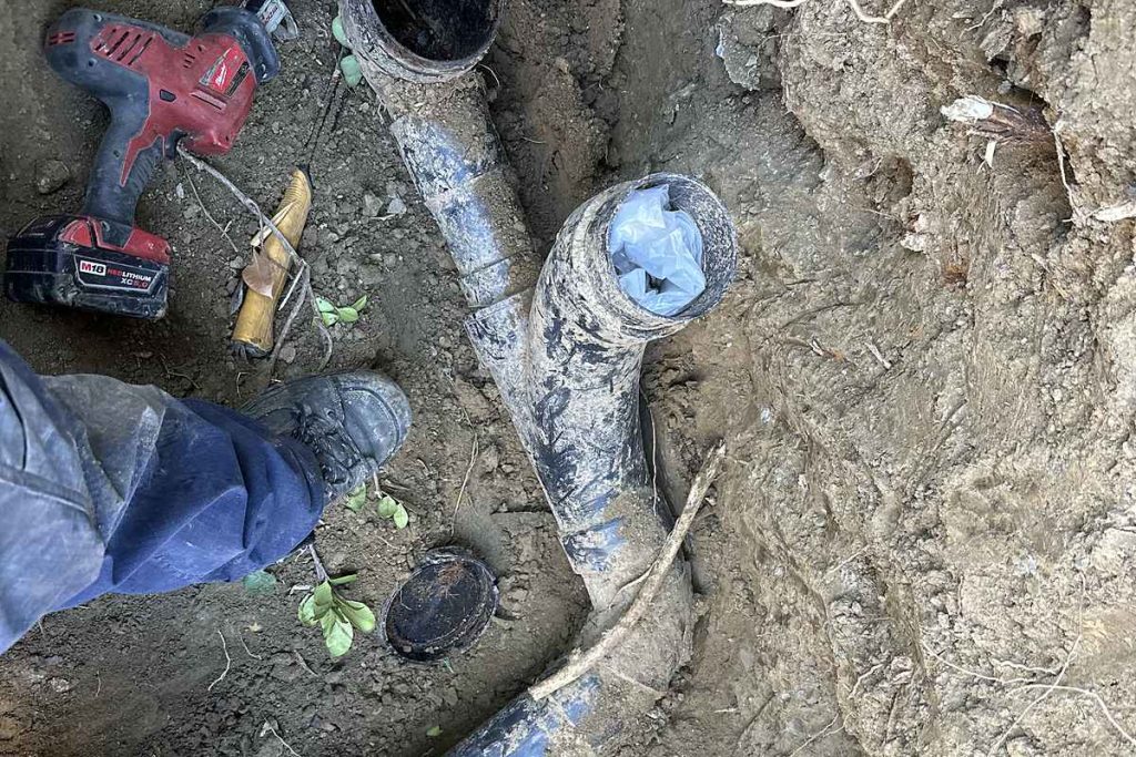 Old cast iron sewer pipes exposed in an excavation