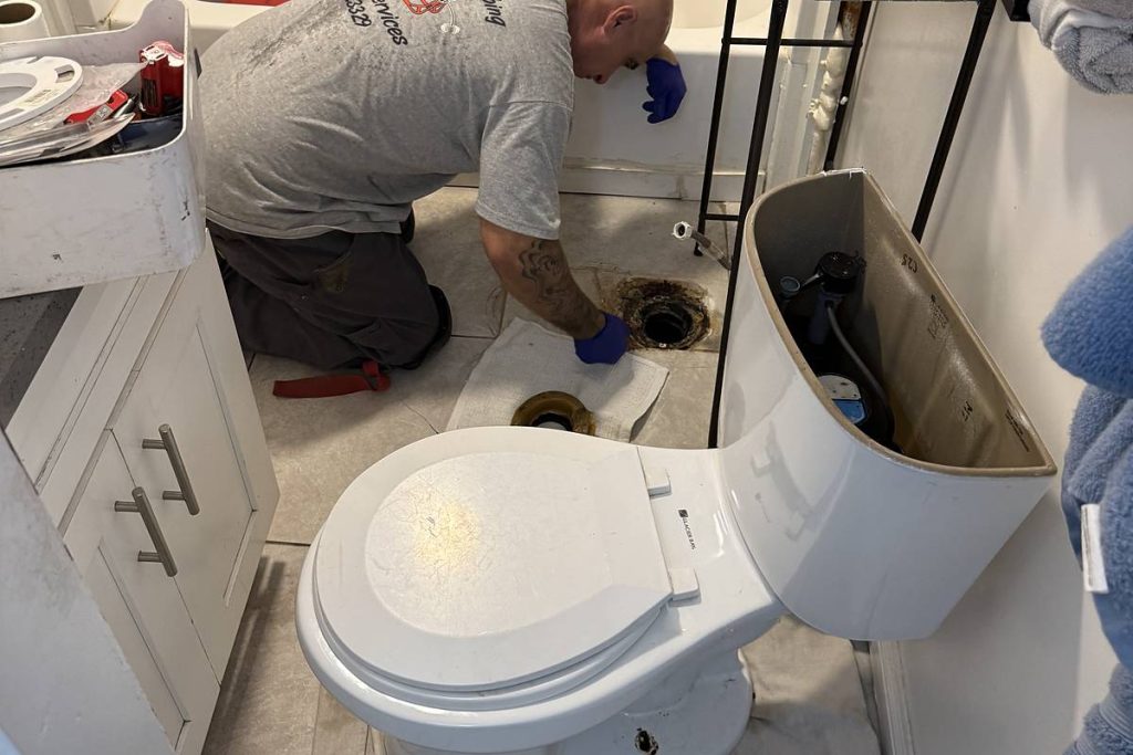 Preferred Plumbing technician setting a toilet in a home bathroom