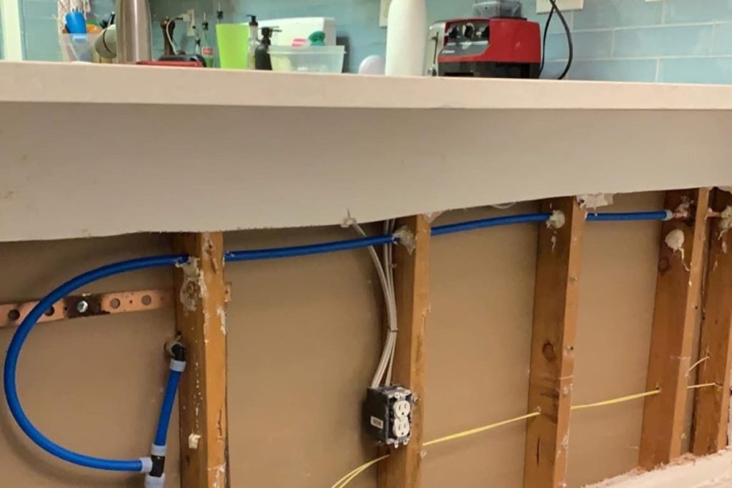 New PEX repipe run through an opened kitchen wall
