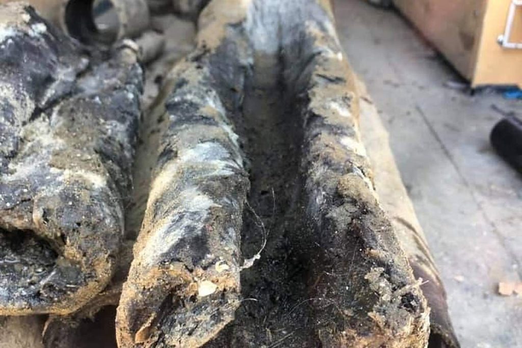 Heavily scaled cast iron drain pipe removed from a home
