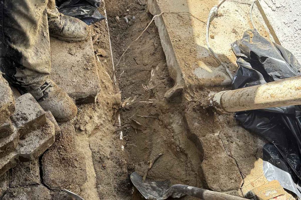 Technician working in an open sewer trench
