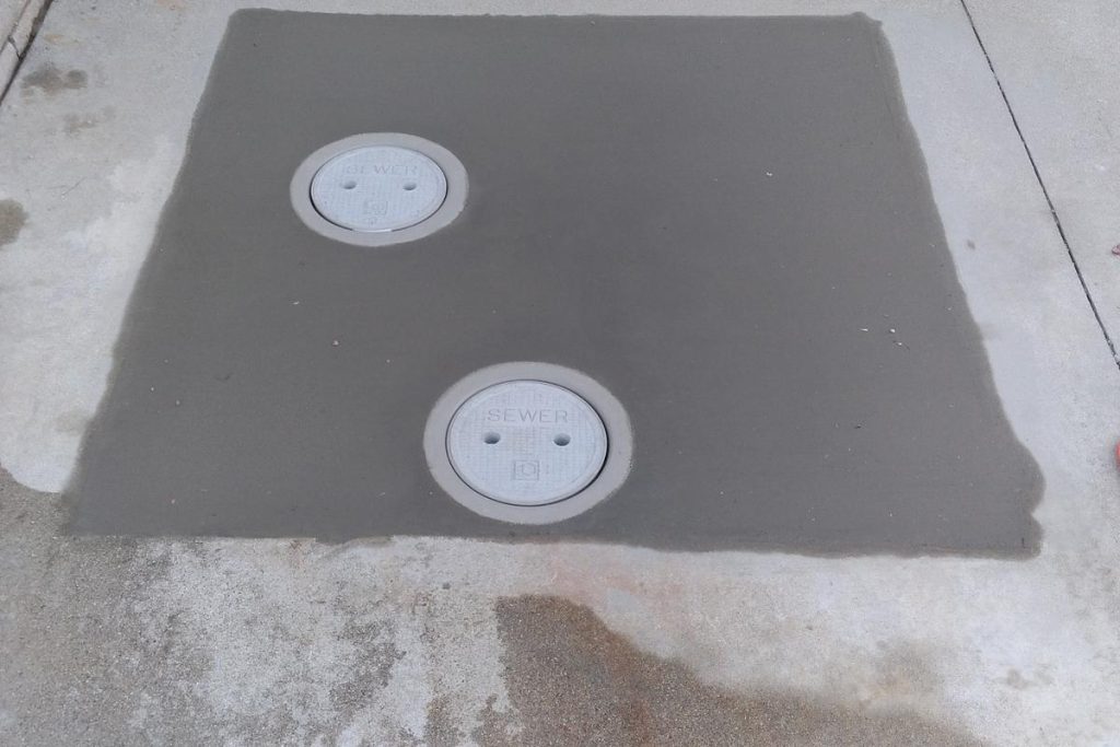 Driveway concrete patched over new sewer cleanouts
