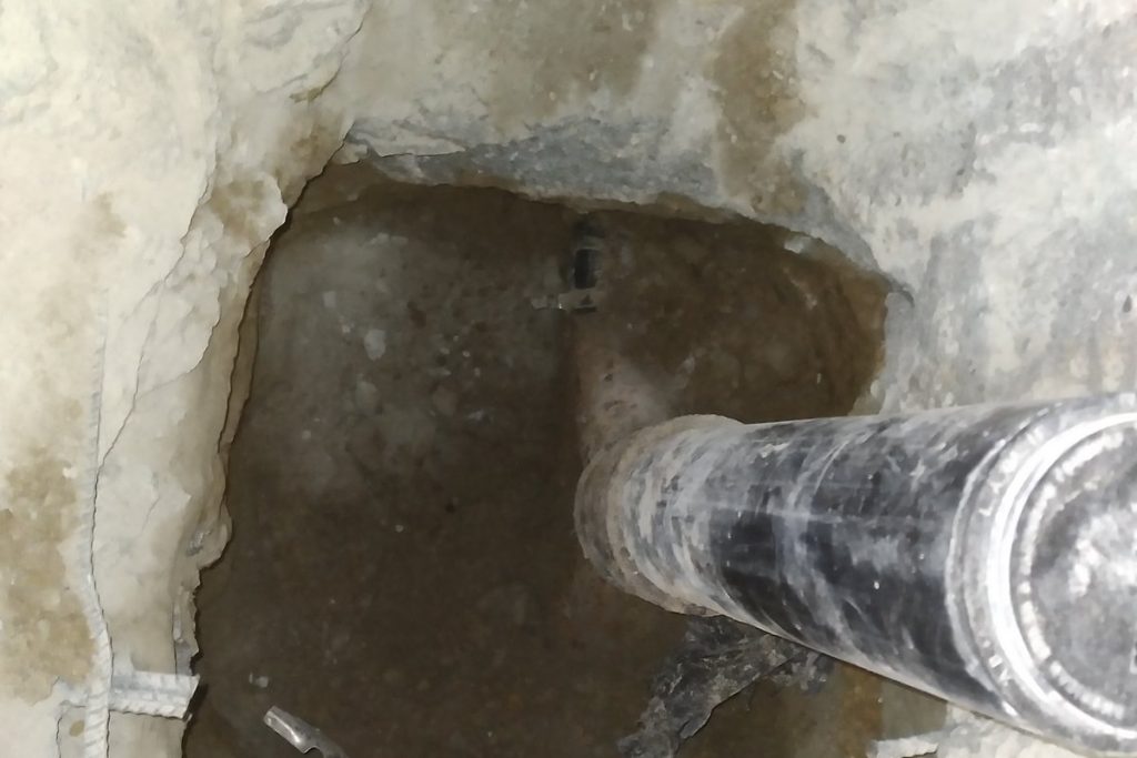 Sewer pipe repaired below an opened concrete slab