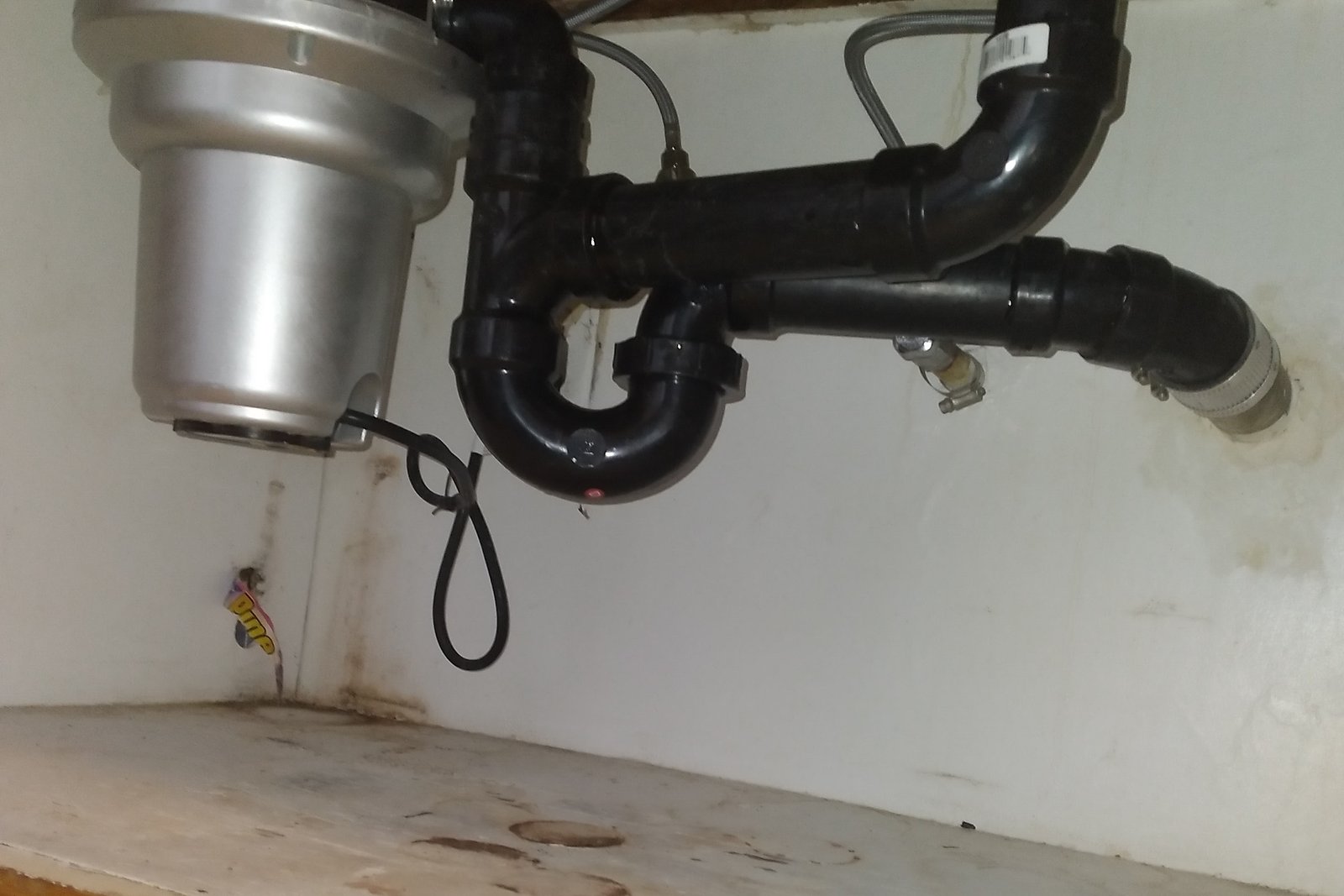 Stainless garbage disposal connected under a kitchen sink