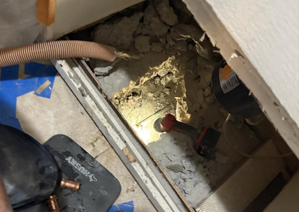 Floor opened under a cabinet to reach a slab leak