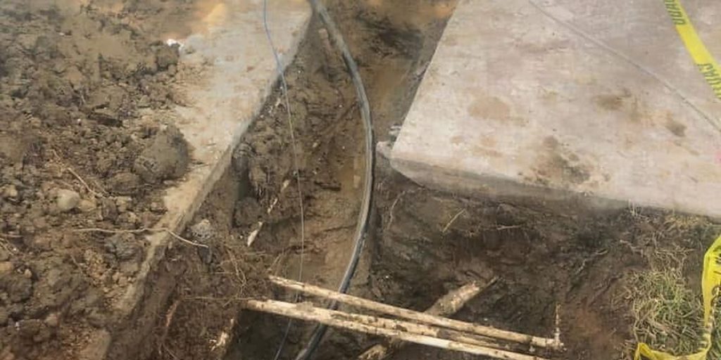 Excavation opened beside the house for a line repair