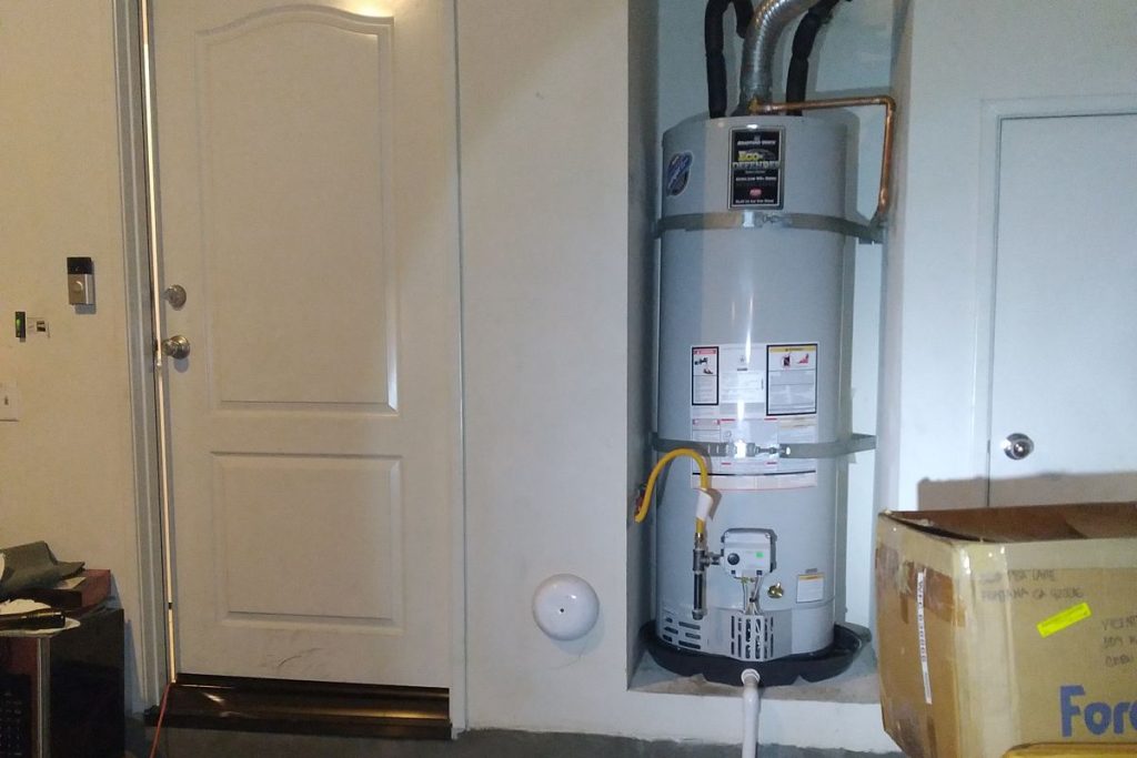 Water heater installed in a garage beside the entry steps
