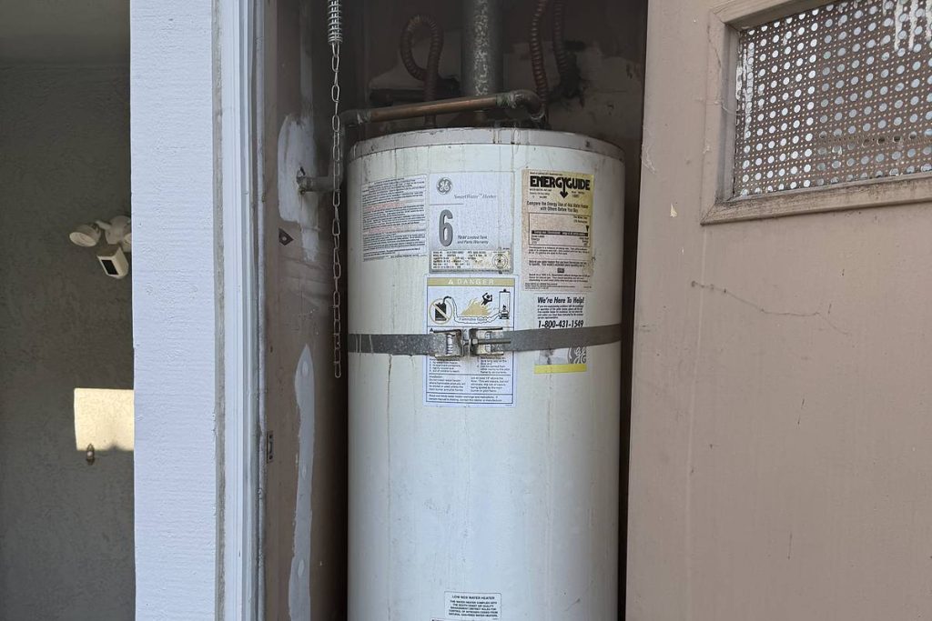 Old water heater in a closet before replacement