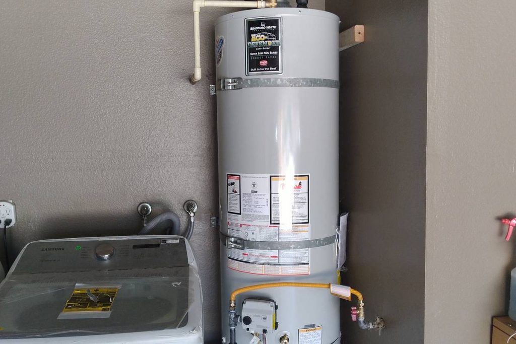 Water heater installed next to a washer in a laundry area